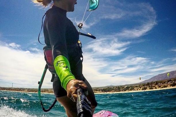 woman kiteboarding on beach